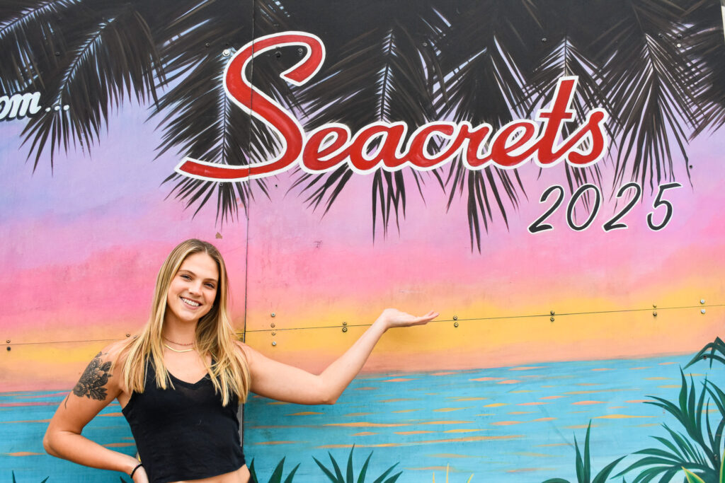 Blonde girl standing in front of a colorful background